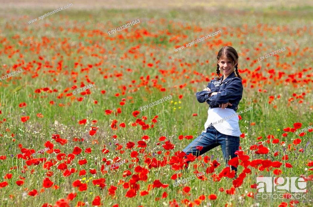 Stock Photo: Girl on the meadow posing with lots of red poppies around her.
