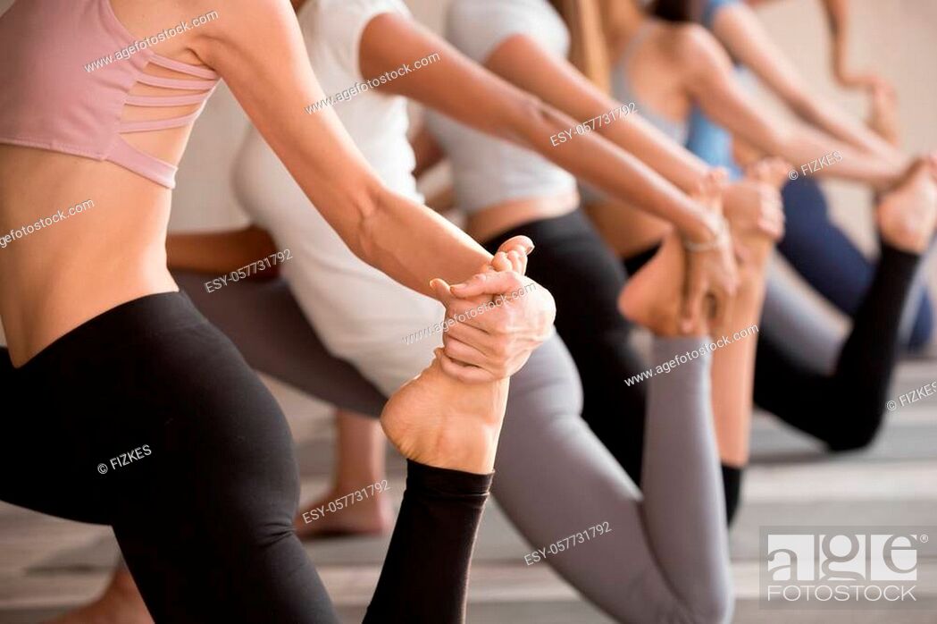 Stock Photo: Group of young diverse sporty people doing yoga Horse rider exercise, anjaneyasana pose, working out, indoor close up, active female students training at club.