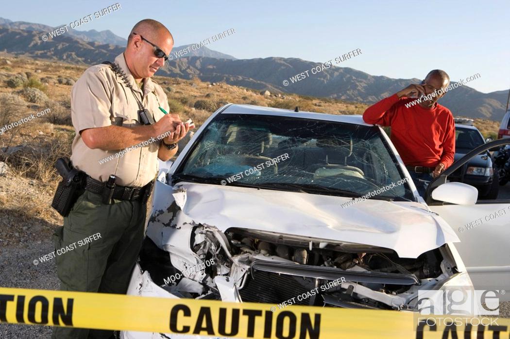Stock Photo: Police officer with man at scene of carcrash.