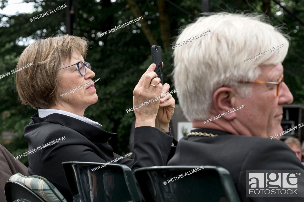 Stock Photo: 06 June 2022, Bavaria, Gerolfingen: Gisela Bornowski, regional bishop of Würzburg-Ansbach, takes photos with her smartphone at the Bavarian Kirchentag.