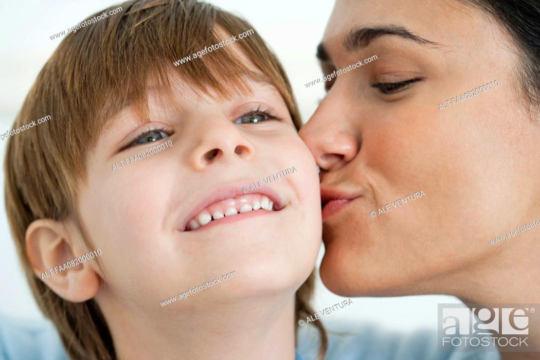 Stock Photo: Mother kissing boy's cheek.