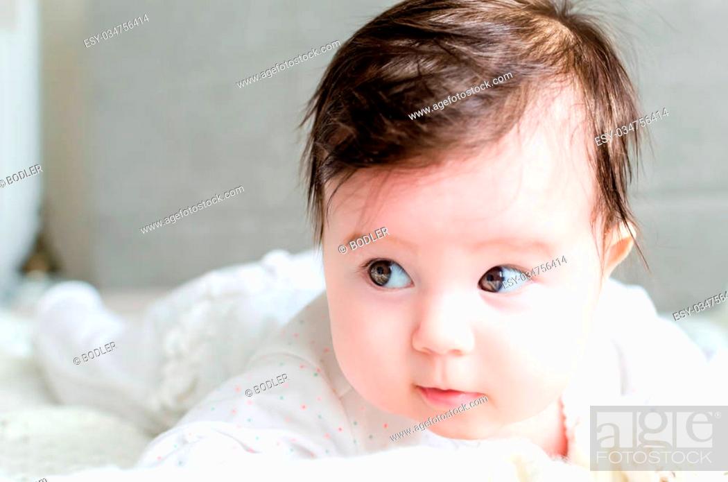 Portrait of cute sweet little newborn baby girl with black brunette hair in  nice white spotted..., Stock Photo, Picture And Low Budget Royalty Free  Image. Pic. ESY-034756414 | agefotostock