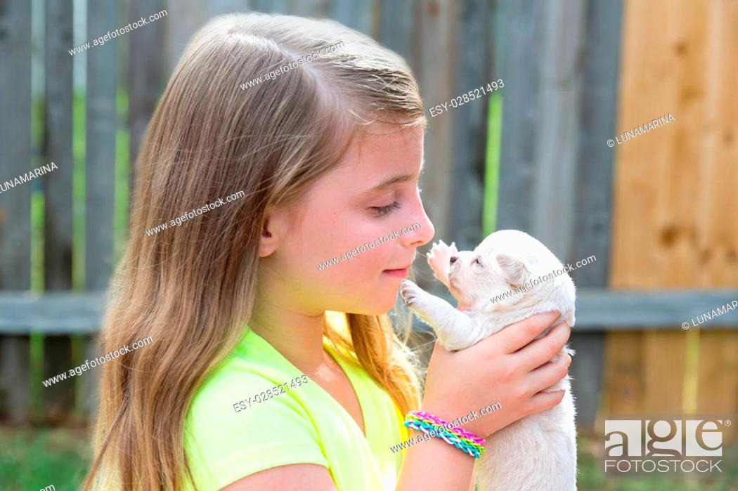 Stock Photo: Blond kid girl with puppy pet chihuahua playing happy with doggy outdoor.