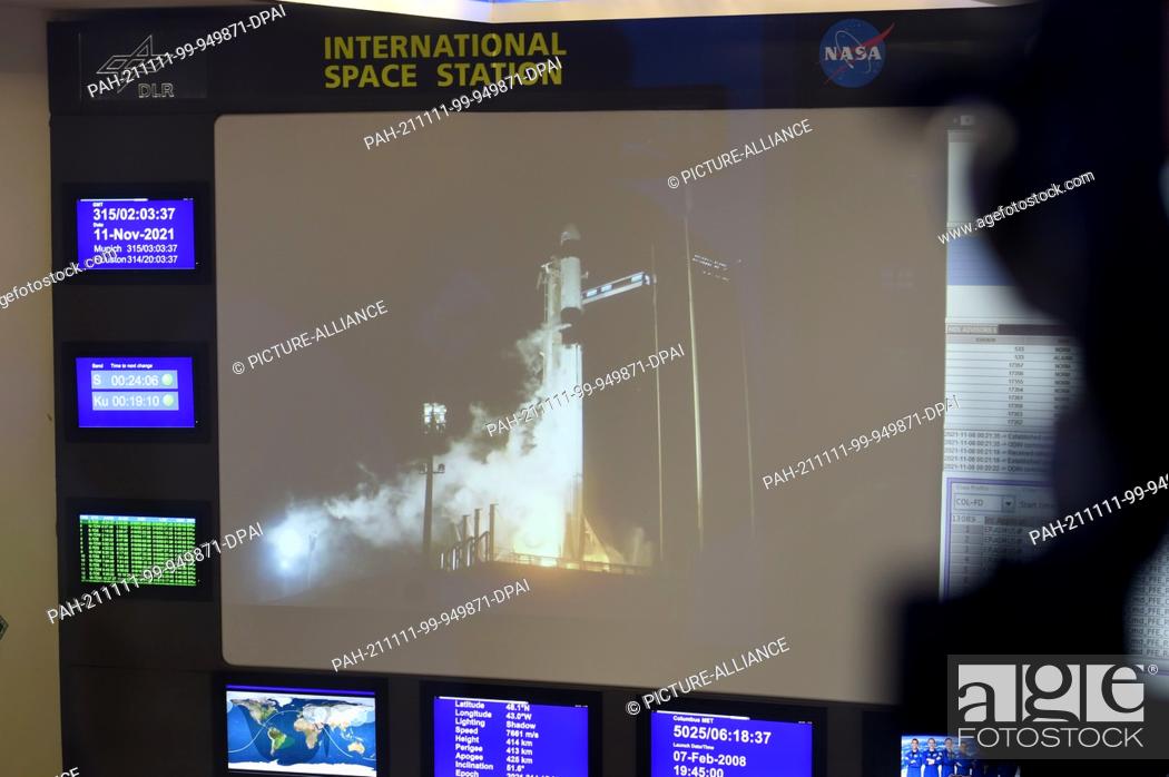 Stock Photo: 11 November 2021, Bavaria, Oberpfaffenhofen: A Falcon 9 rocket from SpaceX can be seen on a large video screen in the Columbus Control Center at the German.