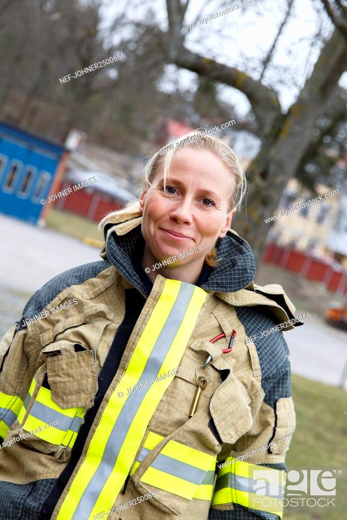 Stock Photo: Smiling female firefighter looking at camera.