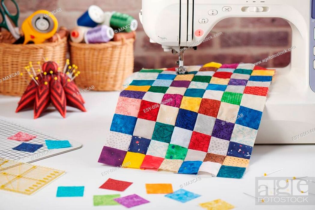 Stock Photo: Colorful detail of quilt sewn from square pieces on sewing machine, quilting and sewing accessories.
