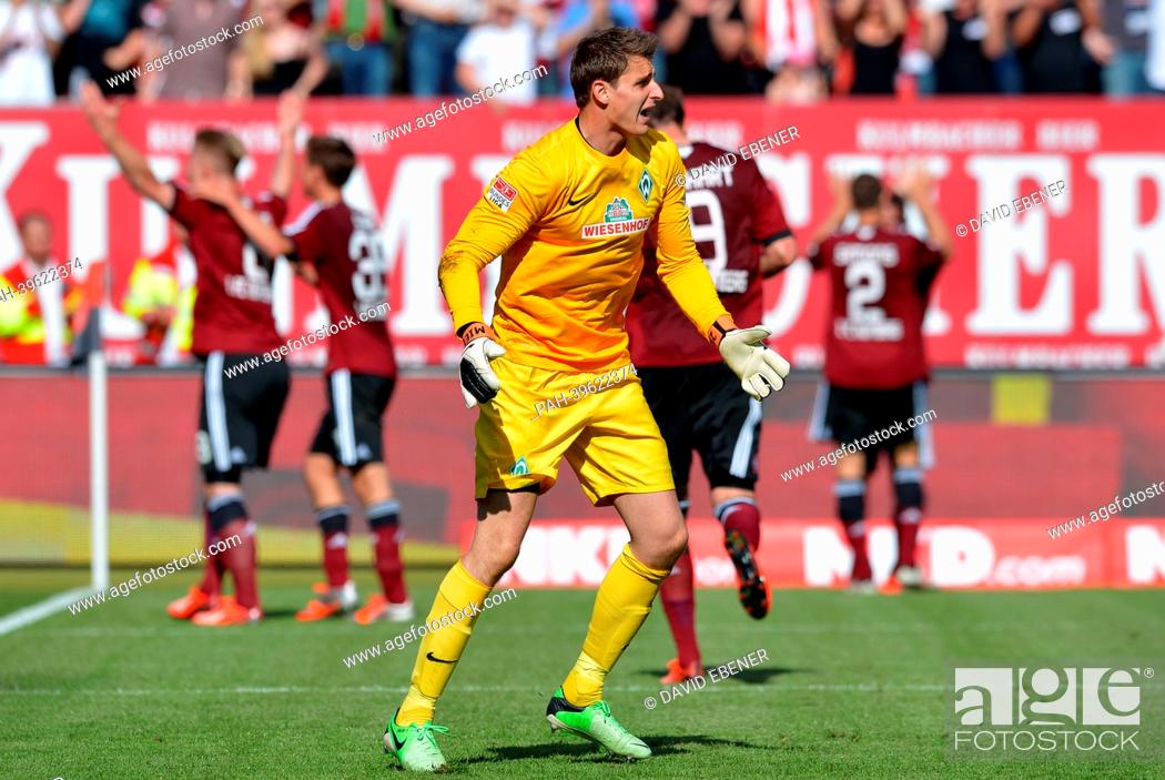 Stock Photo: Bremen's keeper Sebastian Mielitz shouts after the 2-1 goal for Nuremberg, while the goal scorer Sebastian Polter (L) cheers during the Bundesliga soccer match.