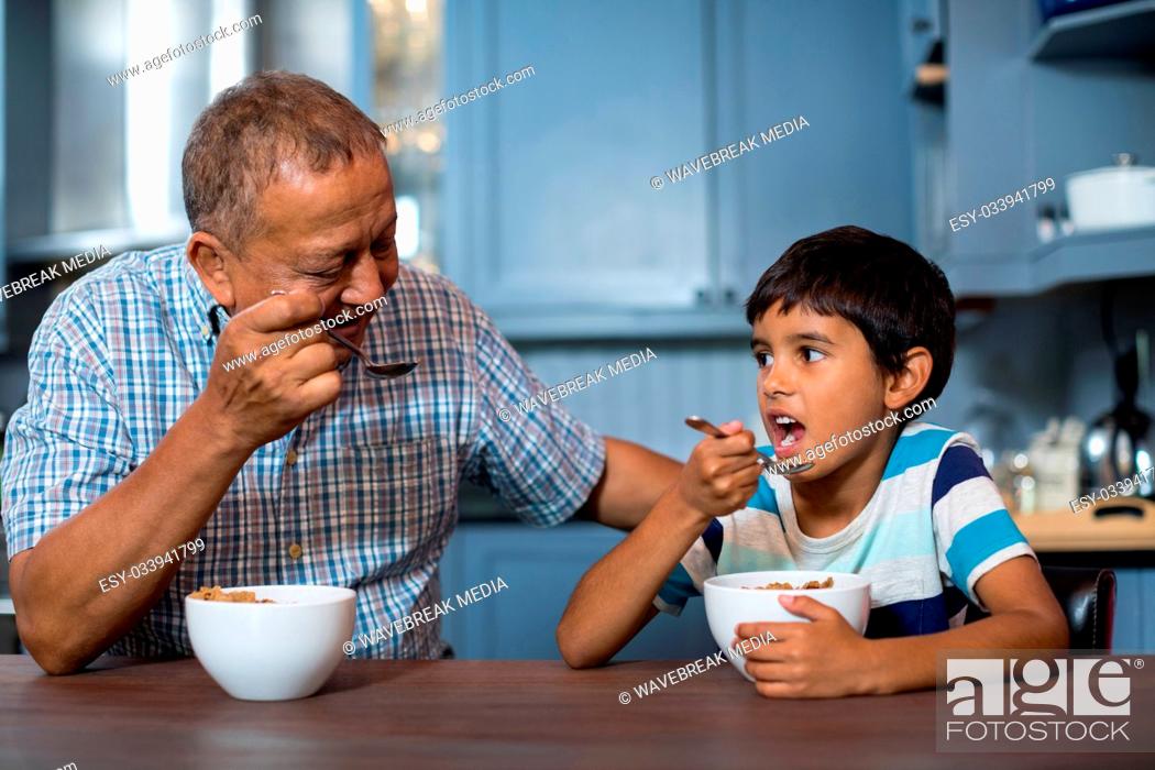 Stock Photo: Grandfather and grandson having breakfast.