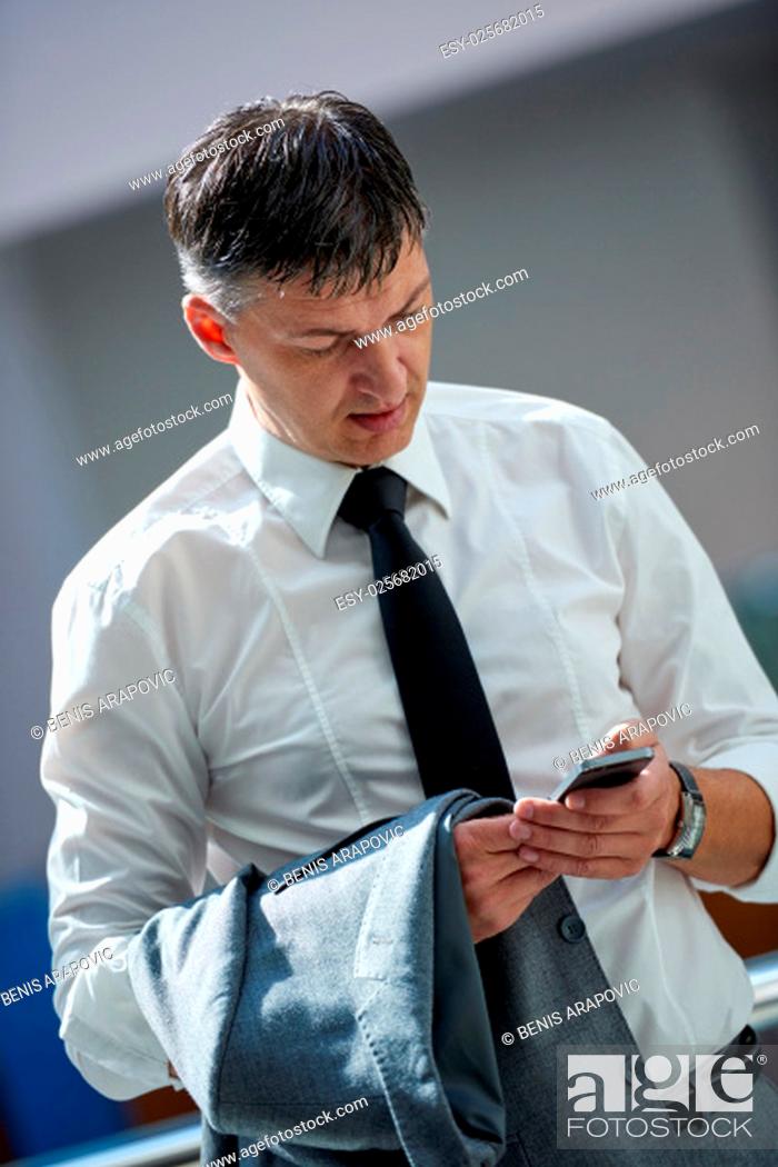 Stock Photo: business man using phone at modern office space.