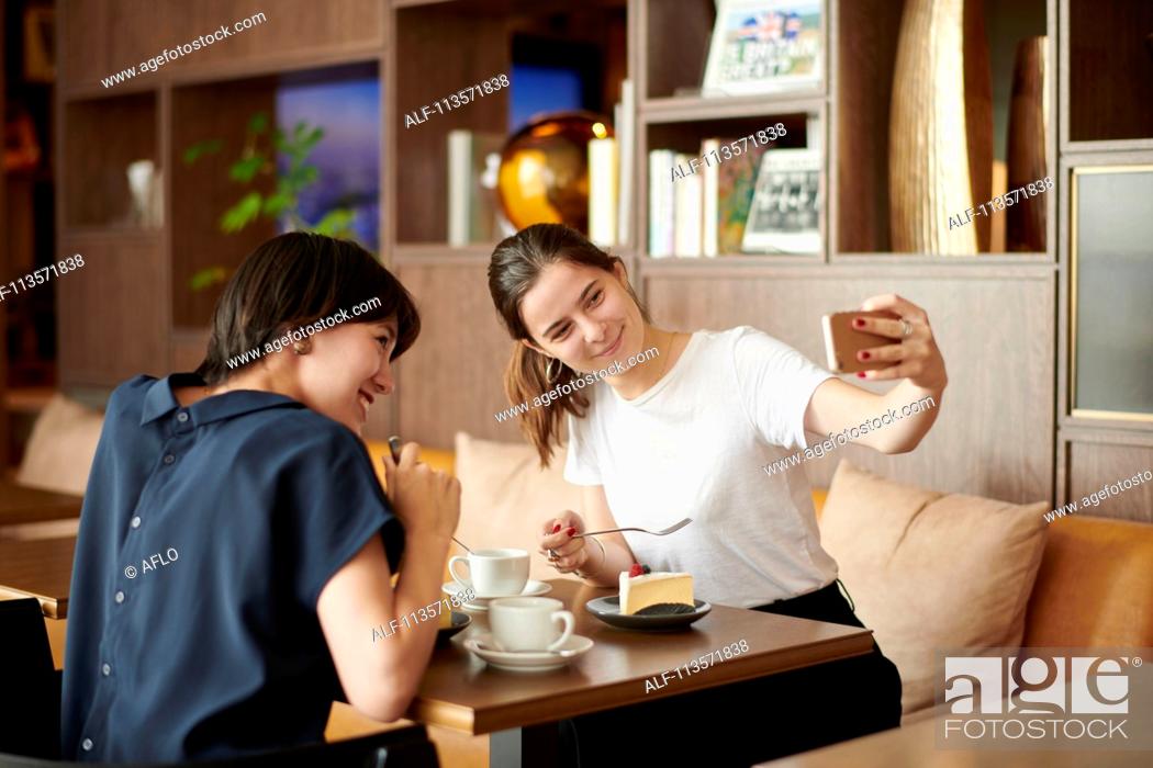 Stock Photo: Young girlfriends at a cafe.