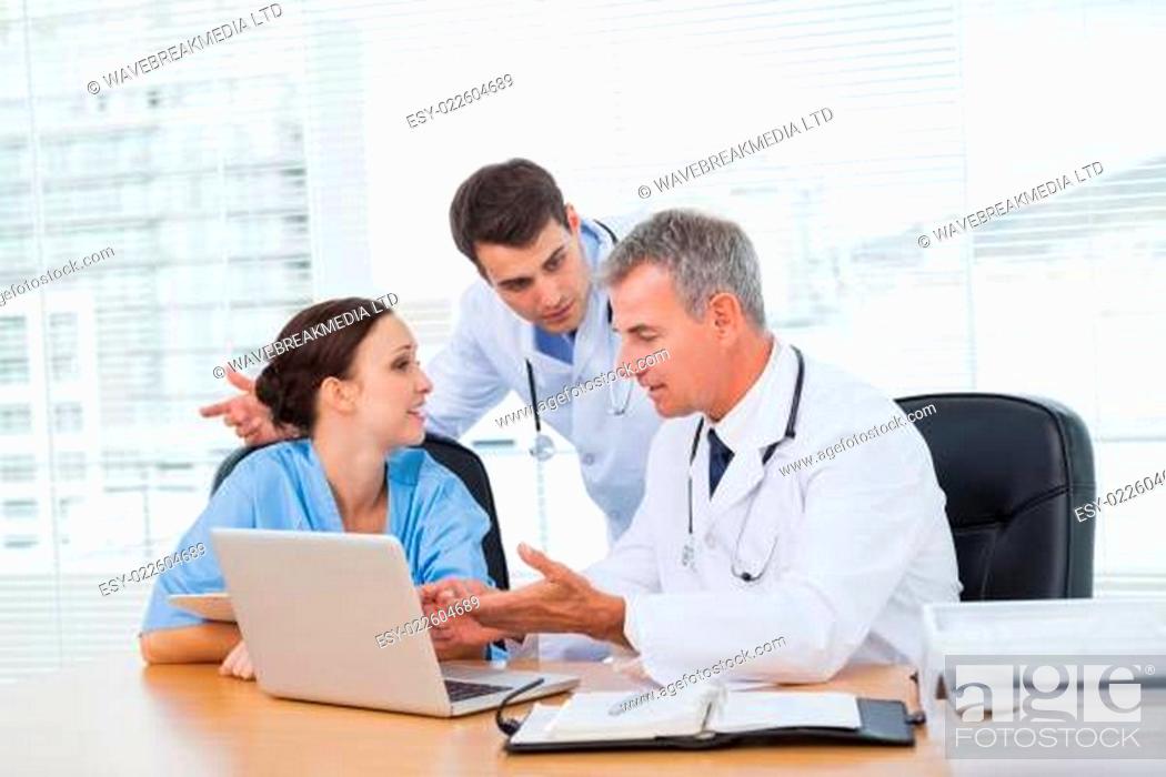 Stock Photo: Doctors and surgeon discussing together.