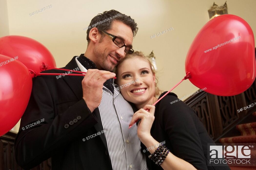 Stock Photo: Amorous couple with balloons on a stairway.