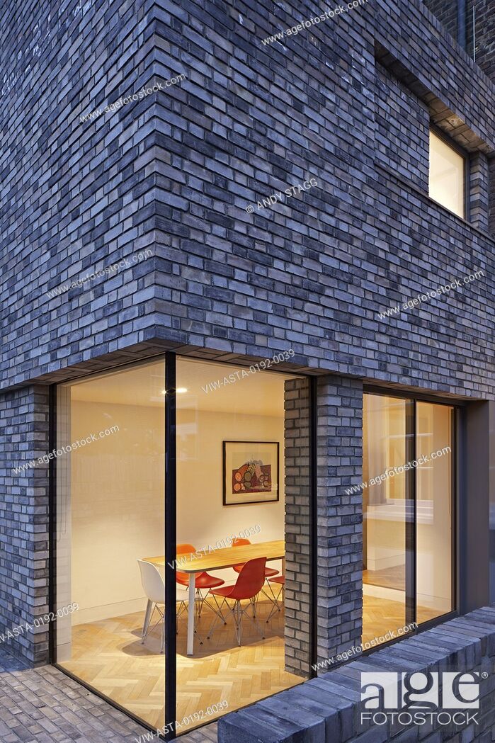 Stock Photo: Dusk view of double-height rear extension with corner window on ground level. Queens House, London, United Kingdom. Architect: Paul Archer Design - Architects &.