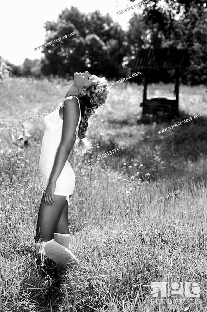 Stock Photo: Giirl walking on the meadow in summer day.