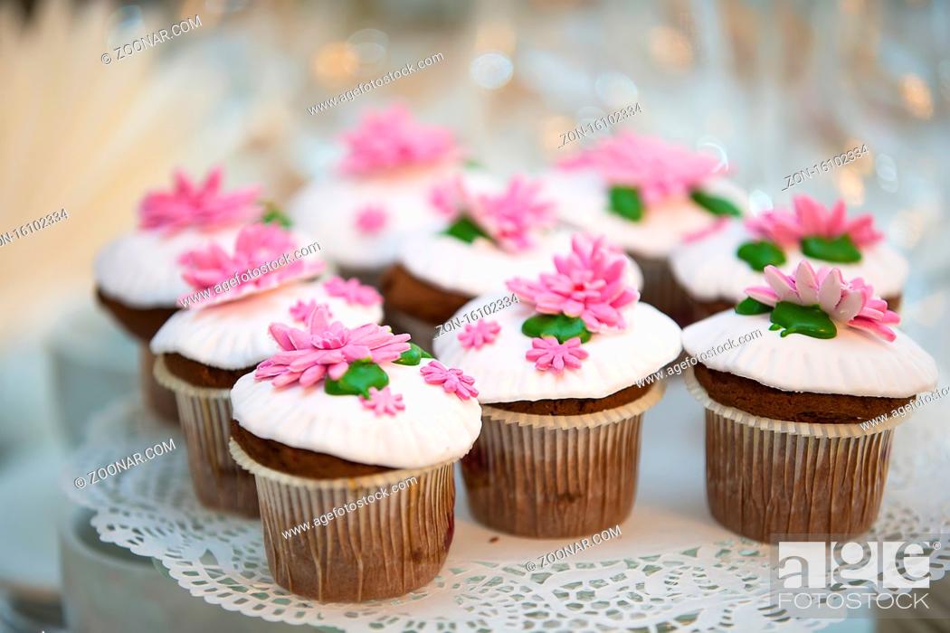 Stock Photo: Cake for a buffet table. A group of small cupcakes decorated with pink cream flowers.