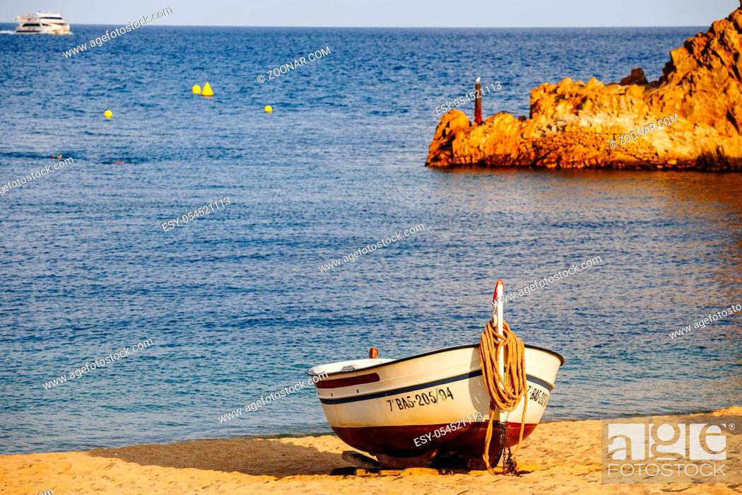 Stock Photo: traditional old wooden fishing boat on the rocky beach. Travel concept. Costa Brava, Spain. Fishing boat rest on golden sand beach overlooking the blue sea.