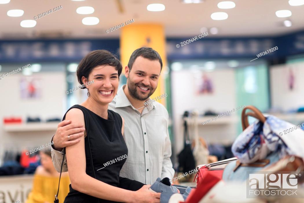 Stock Photo: A young attractive couple changes the look with new shoes At Shoe Store.
