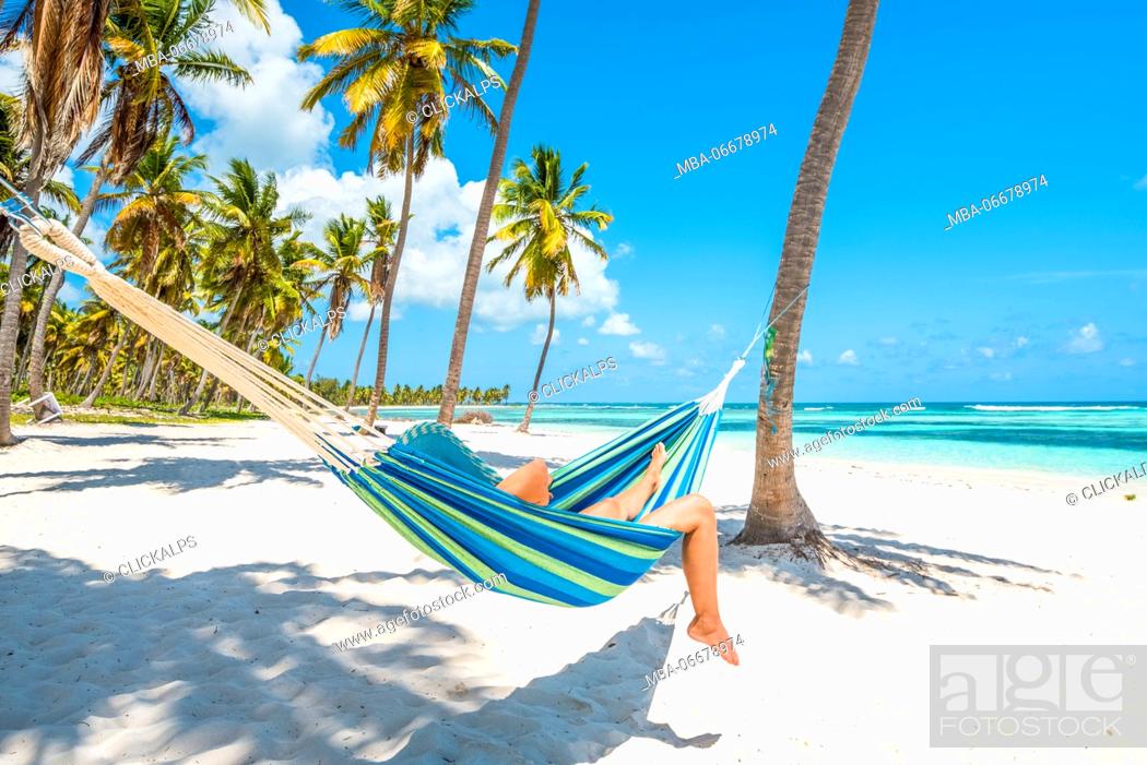 Stock Photo: Canto de la Playa, Saona Island, East National Park (Parque Nacional del Este), Dominican Republic, Caribbean Sea. Woman relaxing on a hammock on the beach (MR).