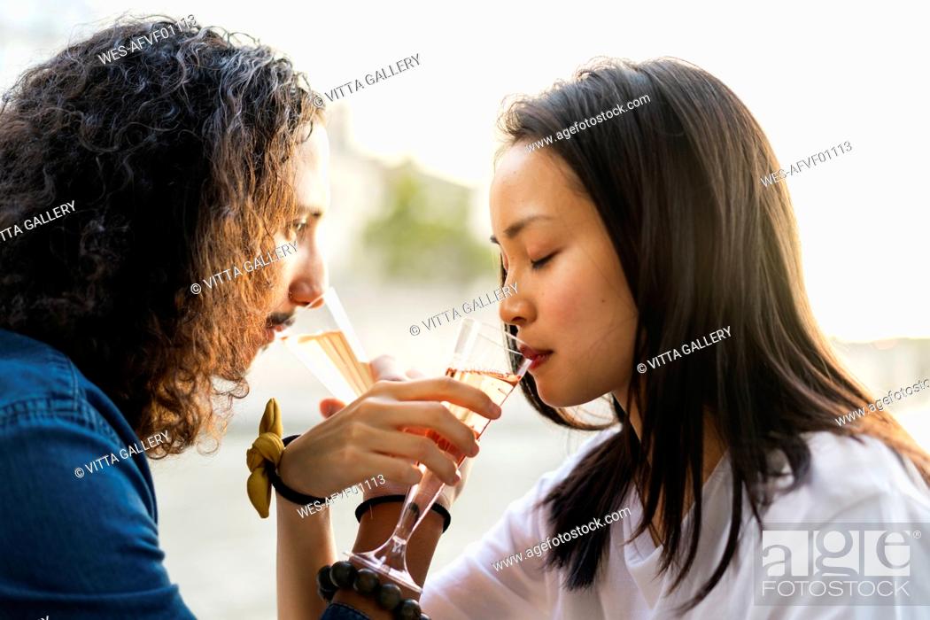 Stock Photo: Young couple drinking champagne at the riverside.