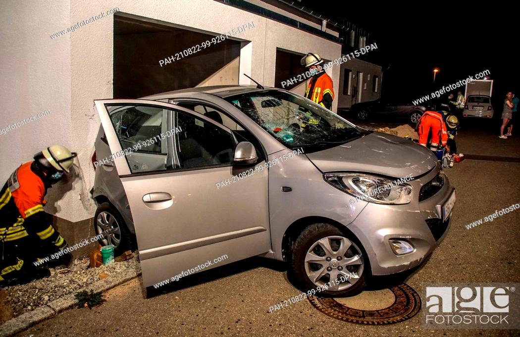 Stock Photo: 22 August 2021, Lake Constance District, Gärtringen: A car is parked at a damaged garage entrance. A senior citizen drove her car into a garage door and a house.