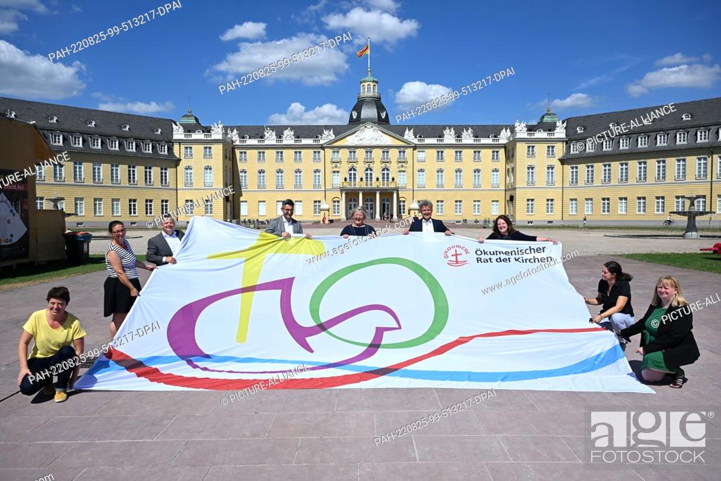 Stock Photo: 25 August 2022, Baden-Wuerttemberg, Karlsruhe: A flag is presented in front of the castle for the 11th Assembly of the World Council of Churches.