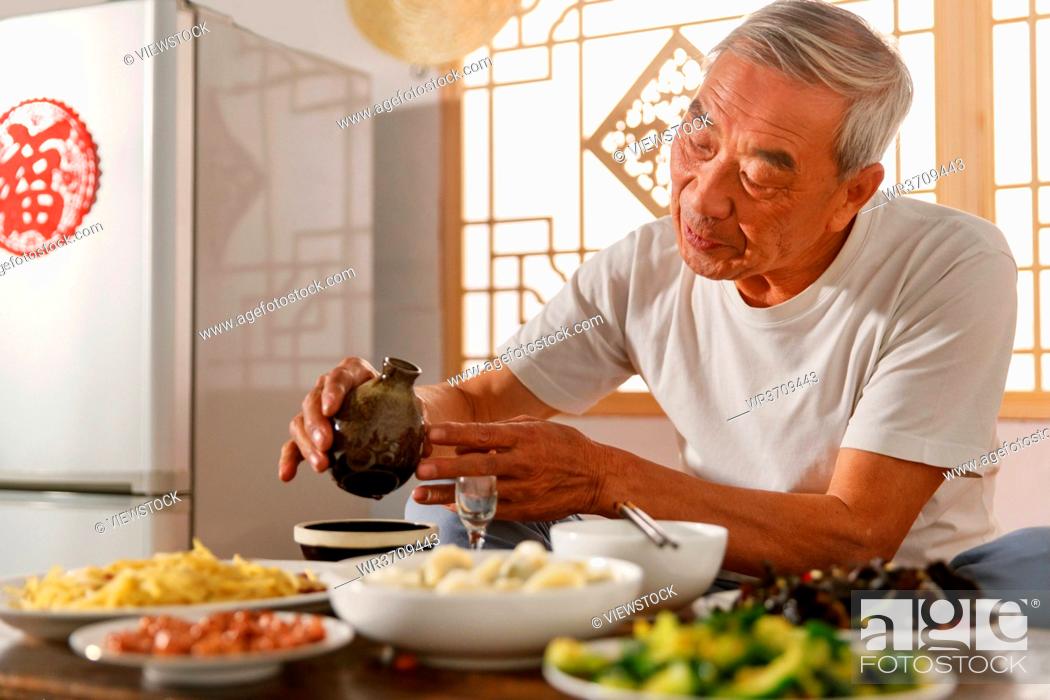 Stock Photo: Old people sitting at home eating drinking.