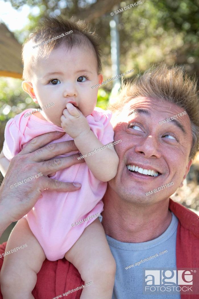 Stock Photo: Father playing with baby girl outdoors.