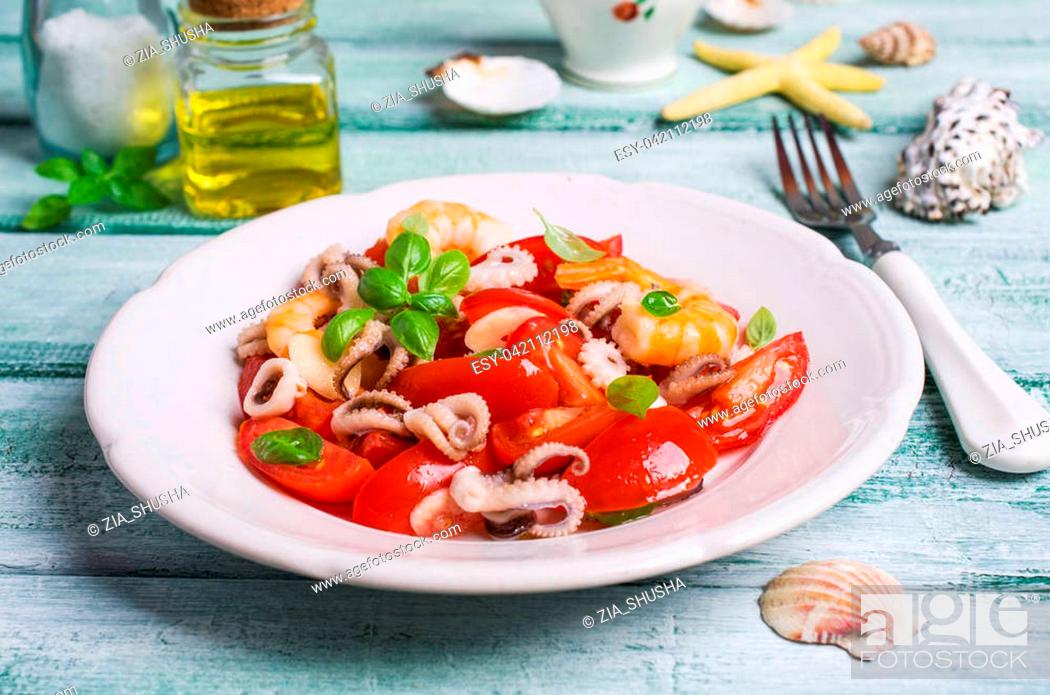 Stock Photo: Salad with seafood and vegetables in a plate on the table. Selective focus.