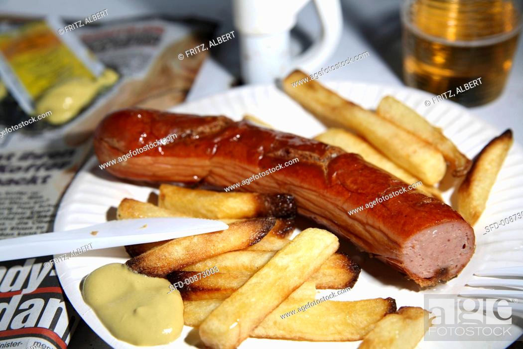 Stock Photo: Sausage with mustard and chips on paper plate.