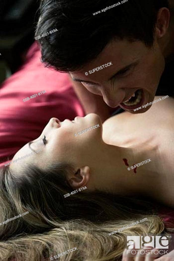 Stock Photo: Vampire sucking blood from a woman's neck.