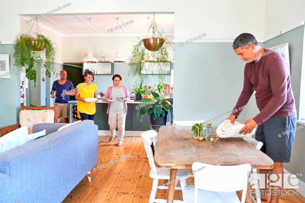 Stock Photo: Mature couples setting dining table for lunch.