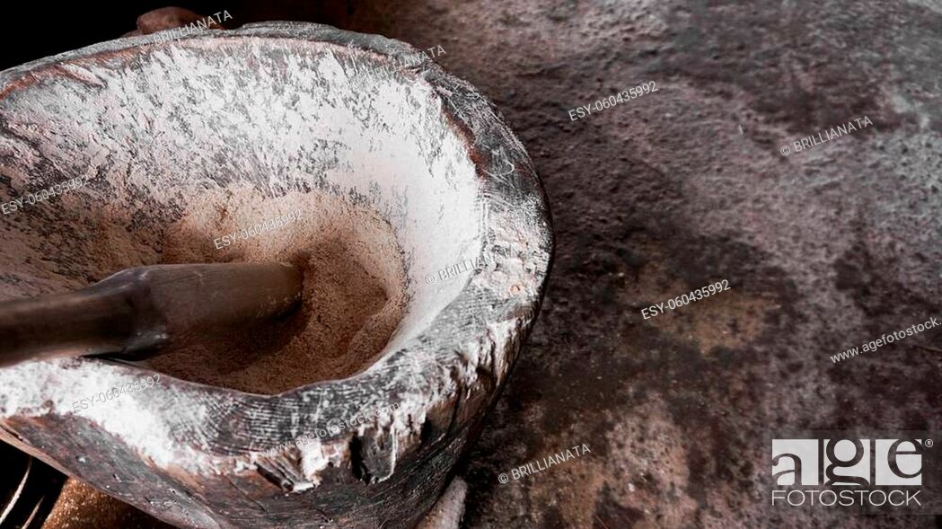 Stock Photo: Ancient flour mortar. Wooden vessel for manual hand grinding. Authentic craft workshop. This method has been in use for many thousand years.