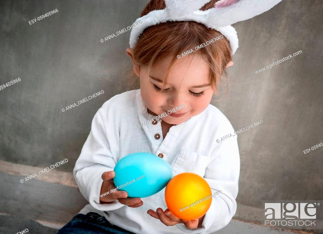 Stock Photo: Cute Little Baby Dressed as Festive Bunny Playing with Colorful Eggs. Enjoying Happy Easter Holiday. Great Christianity Holiday.