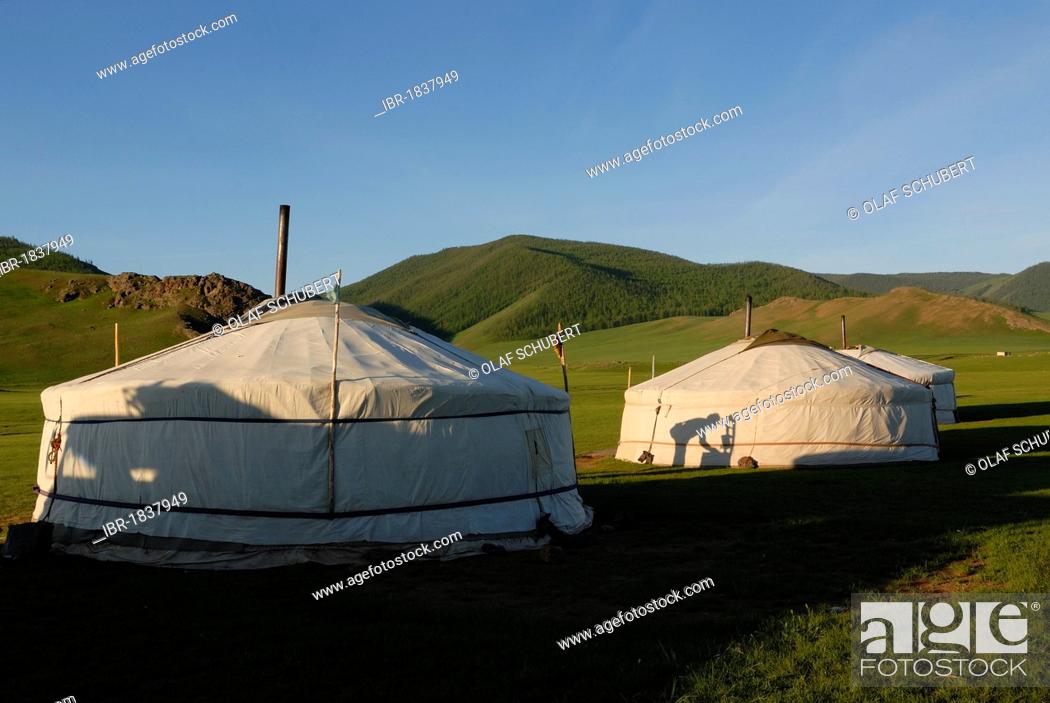 Stock Photo: Yurt or ger camp with the shadow of a man washing himself, grassland at the Orkhon Waterfall in front of the mountains of Khangai Nuur National Park.