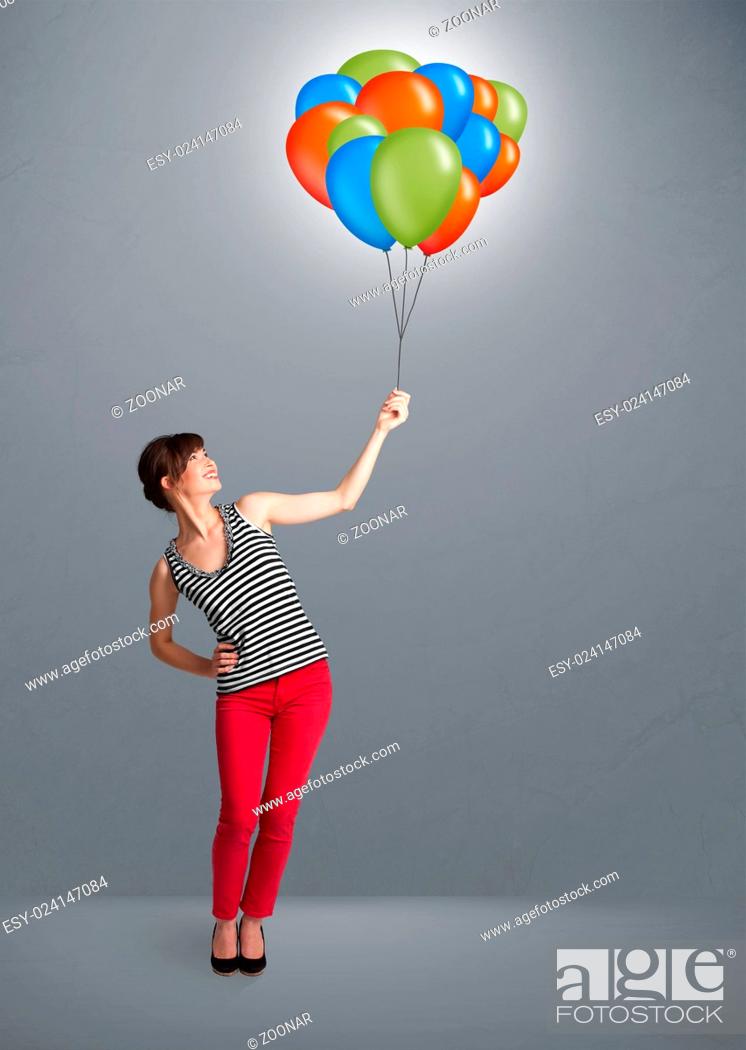 Imagen: Young woman holding colorful balloons.