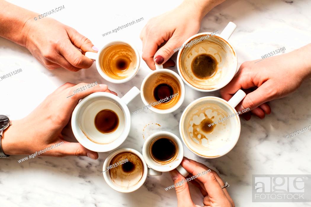 Stock Photo: Top view hands holding empty and dirty cups of coffee afterparty.