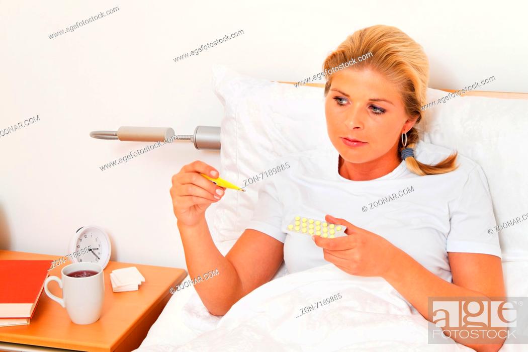 Stock Photo: Eine Frau im Bett ist Krank und hat Fieberthermometer.