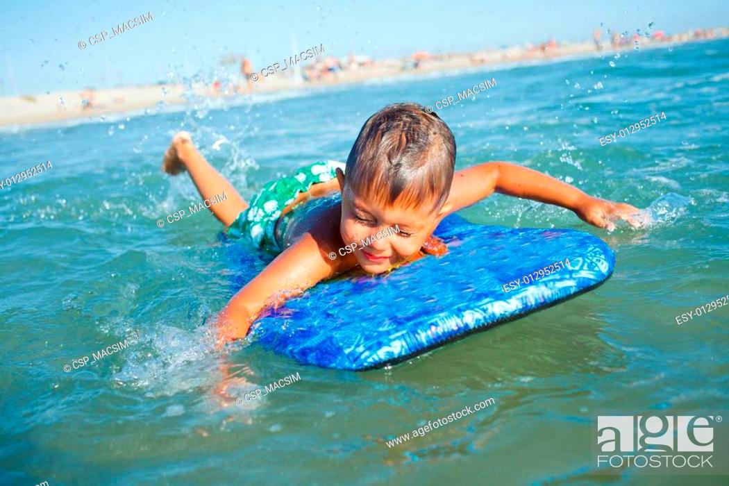 Stock Photo: boy has fun with the surfboard.