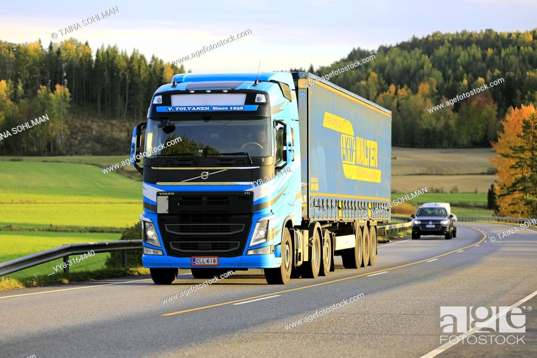 Stock Photo: Salo, Finland - October 5, 2018: Blue Volvo FH semi trailer transports goods near sunset time along autumnal highway in South of Finland.