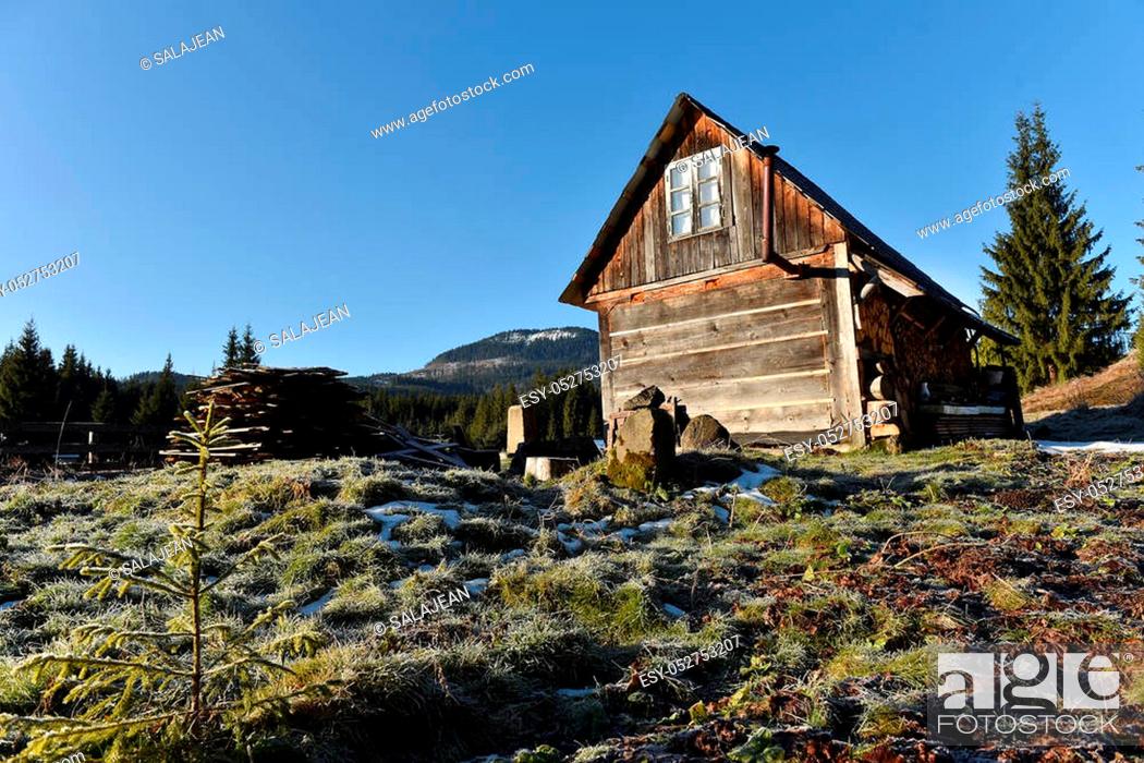 Stock Photo: Wooden cottage in the mountains in a cold winter morning.