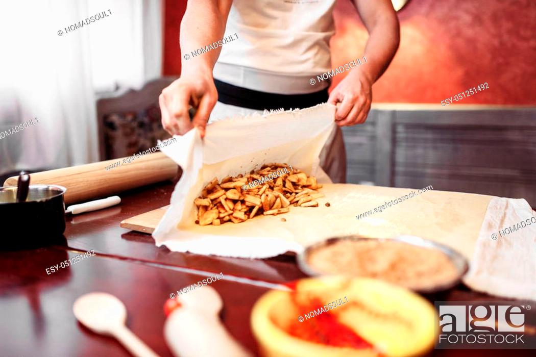 Stock Photo: Male chef wraps the filling into dough, apple strudel preparation process. Homemade sweet dessert.