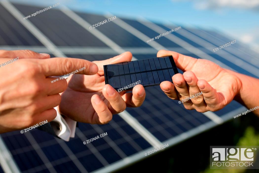 Stock Photo: Solar energy, two hands holding photovoltaic item. Solar panels in the field, close yp view on photovoltanic detail.