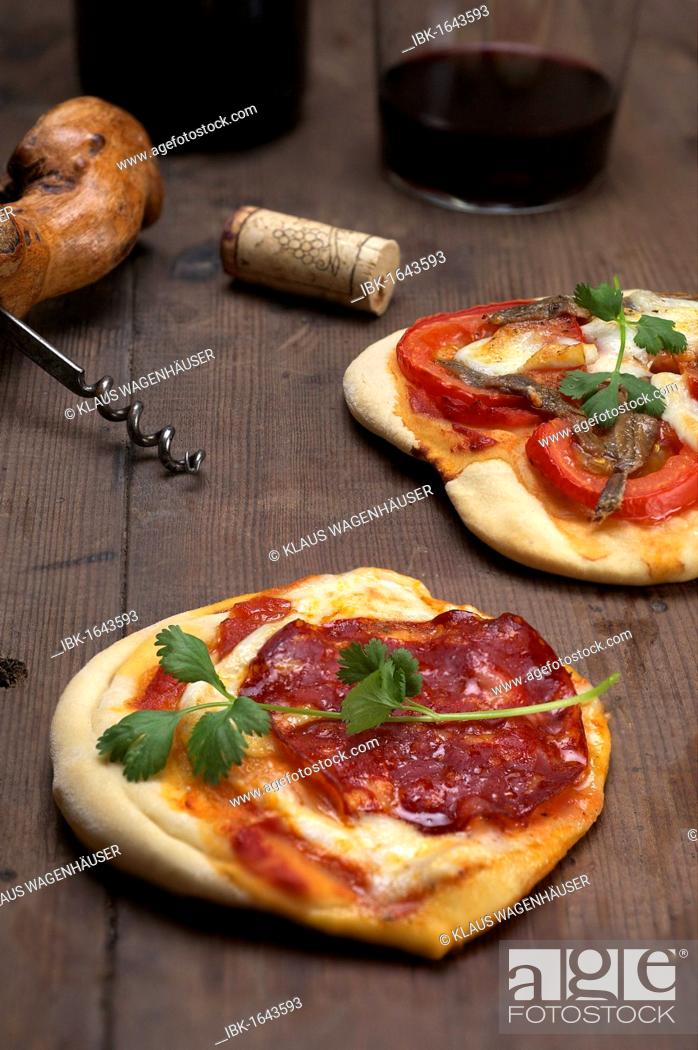 Stock Photo: Pizzette, small pizzas with buffalo mozzarella, chorizo and coriander, front, and tomatoes and anchovies, rear.
