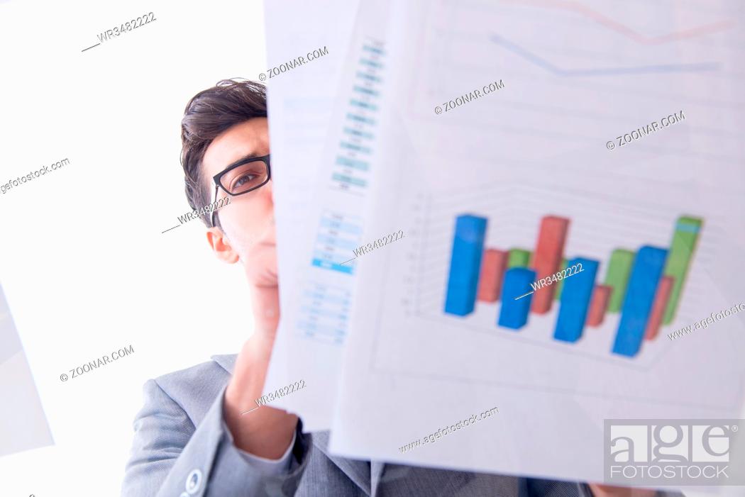 Stock Photo: Businessman looking at financial charts and graphs.