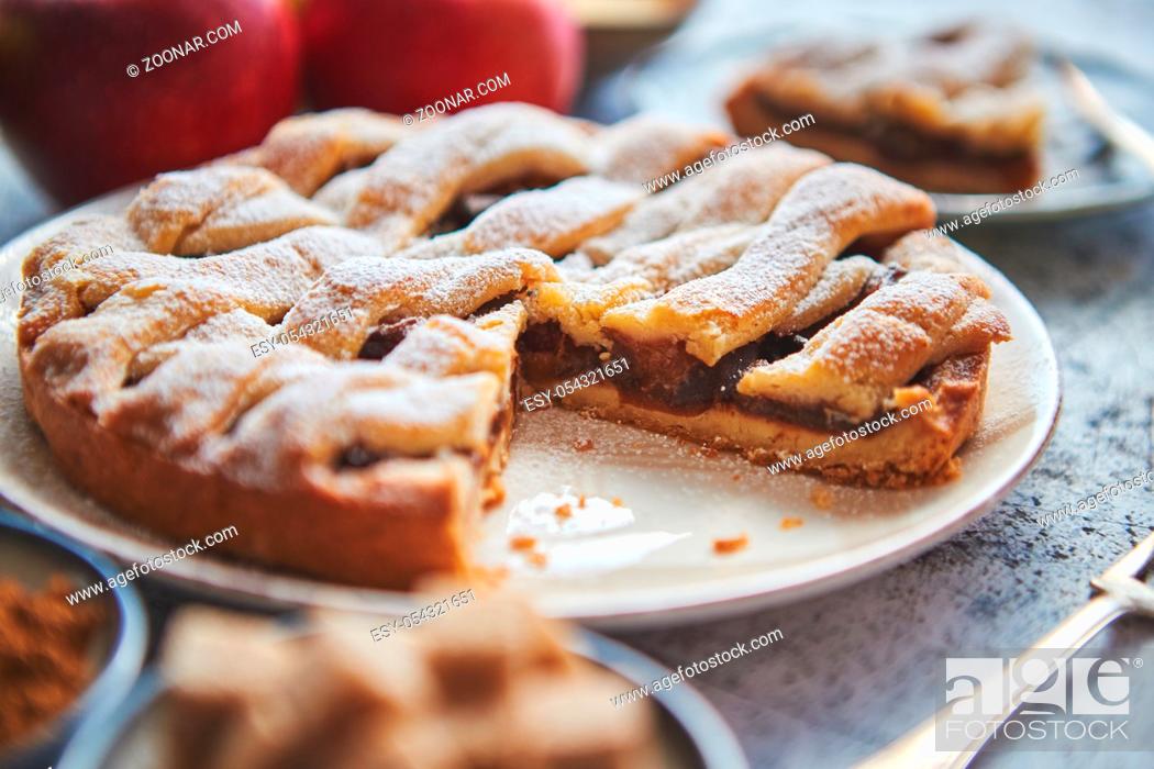 Stock Photo: Fresh baked apple pie with cutted slice on small plate. With ingrediends on side. Fresh fruits, brown sugar cubes, cinnamon.