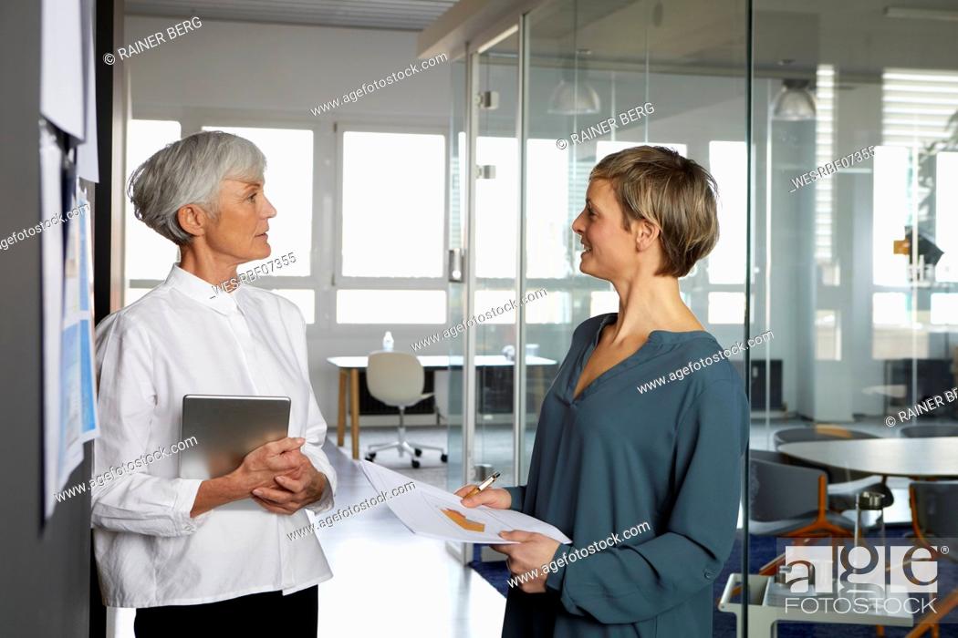 Stock Photo: Two businesswomen talking in office.