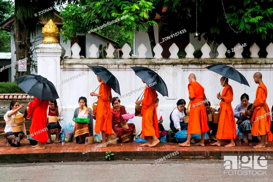 Stock Photo: Traditional Alms giving ceremony of distributing food to buddhist monks on the streets of Luang Prabang Laos.