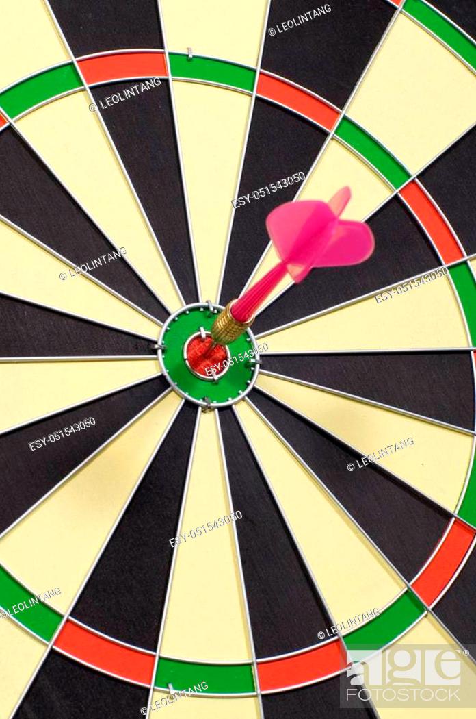 Stock Photo: Dart hitting a target on circular dart board.