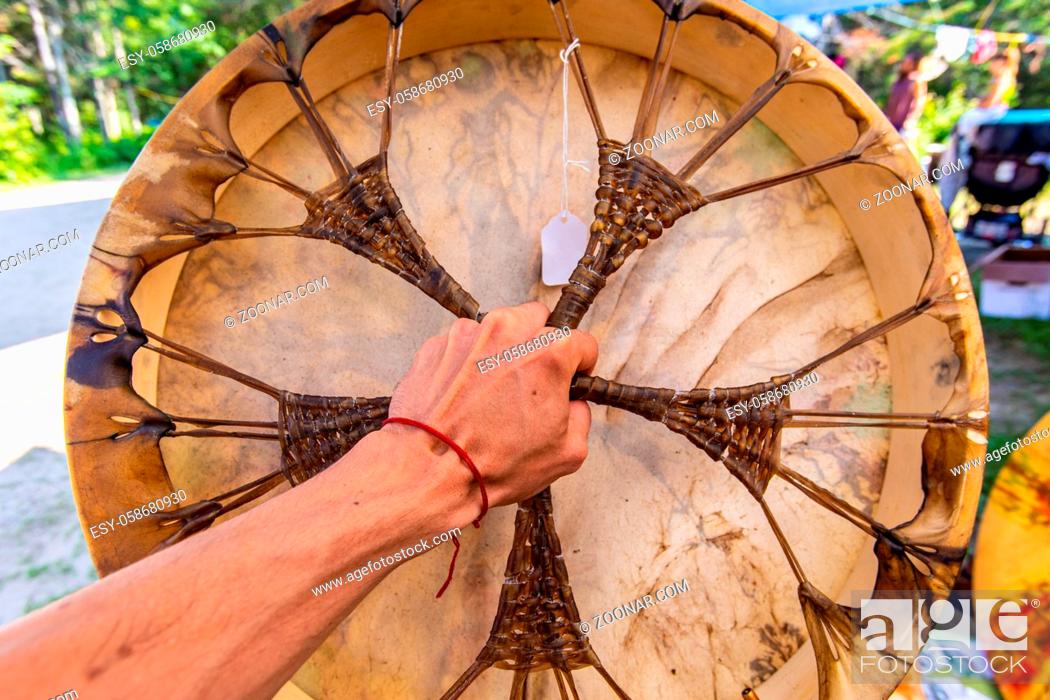Stock Photo: selective focus on caucasian women hand playing Sacred drum, close up on colourful Native American leather drum during a music celebration in a park.