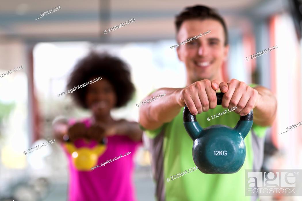 Stock Photo: healthy couple workout with weights lifting dumbbels at crossfit gym african american woman with afro hairstyle.